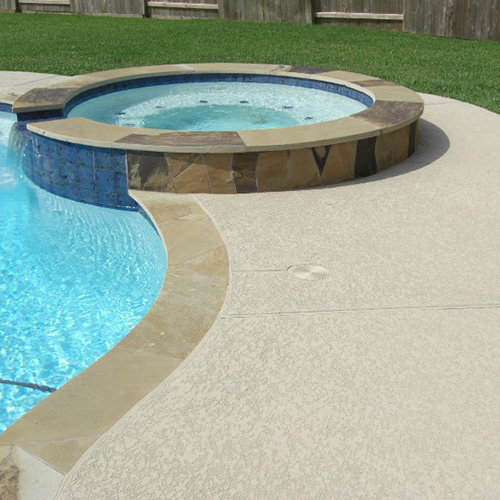 A modern pool with custom concrete deck coating in Houston, designed by Houston Pool Renovations