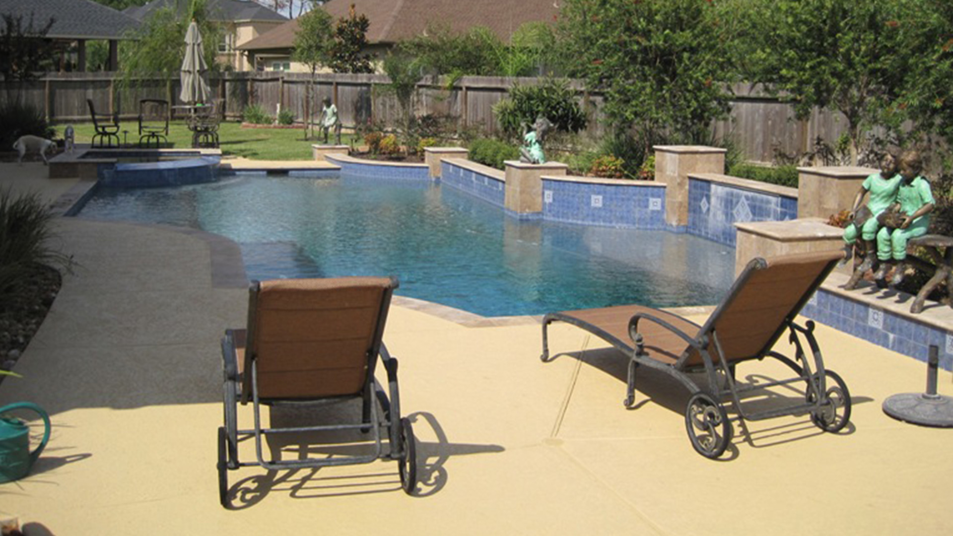 A modern pool with custom concrete deck coating in Houston, designed by Houston Pool Renovations