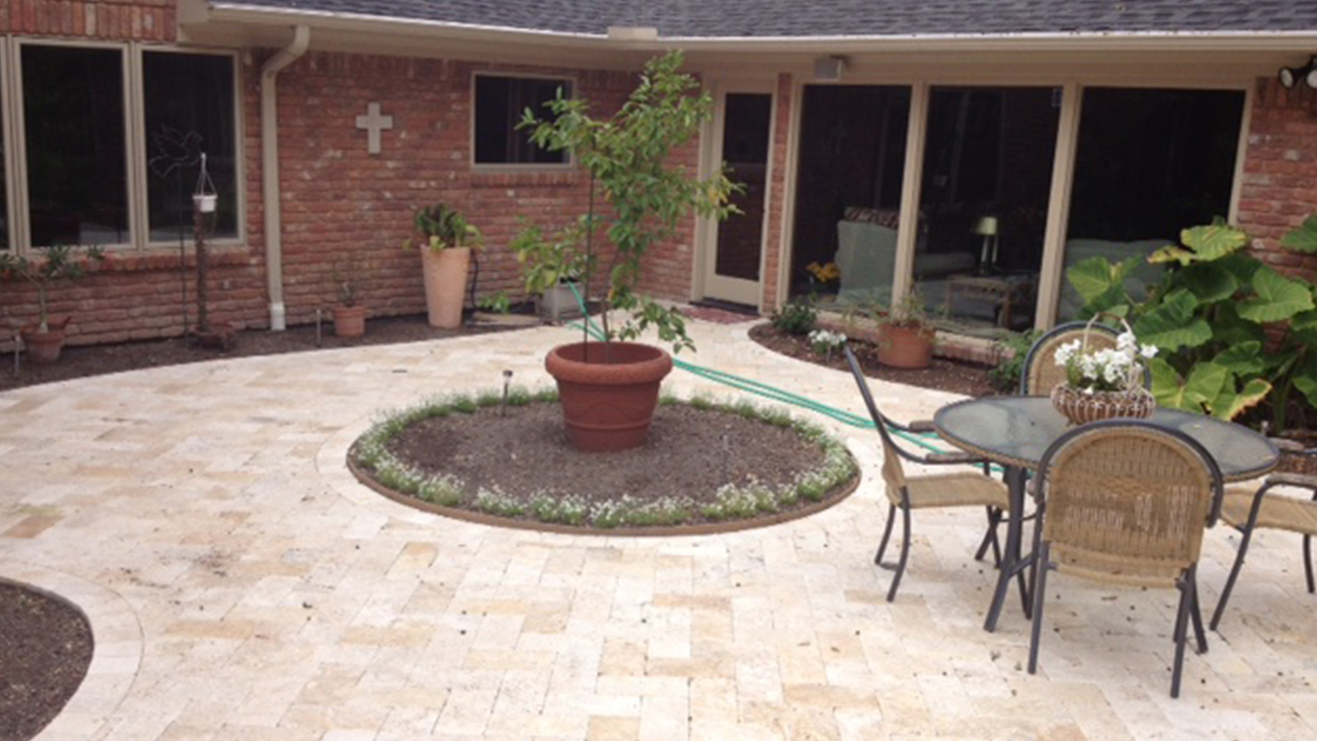 A custom deck featuring natural stone pavers, designed and installed by Houston Pool Renovations, adding elegance to a backyard space.