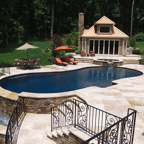 A beautifully remodeled pool in Houston, surrounded by lush landscaping, showcasing the quality work of Houston Pool Renovations.