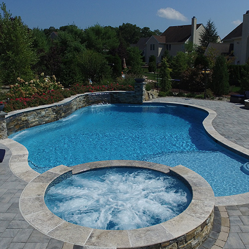 A beautifully remodeled pool in Houston, surrounded by lush landscaping, showcasing the quality work of Houston Pool Renovations.